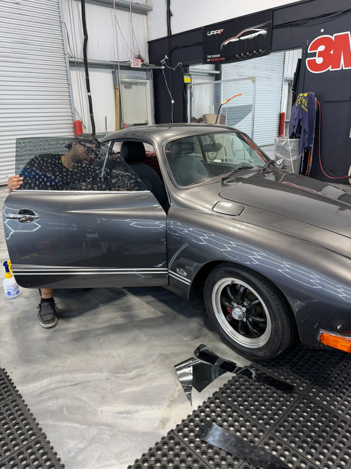 LeWolf installer fitting tinted door glass on a classic coupe in the Magnolia install bay