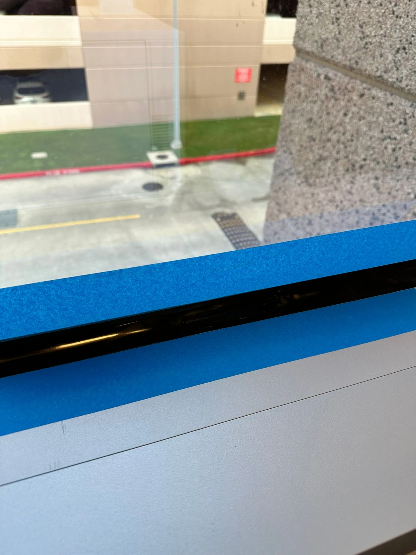 Close-up of security window film edge and frame detail during installation
