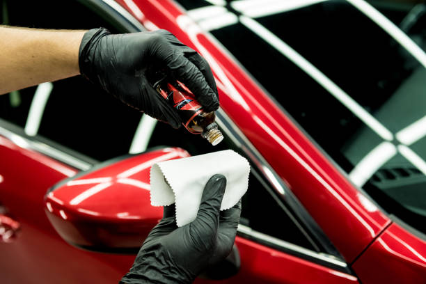 Technician applying ceramic coating to a red sports car at LeWolf