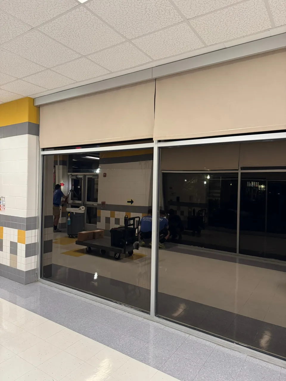 LeWolf crew applying security film to school corridor glass after hours